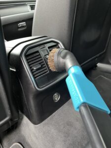 Odkurzanie tylnych kratek nawiewu miękką szczotką podłączoną przez niebieski adapter MojaSsawka